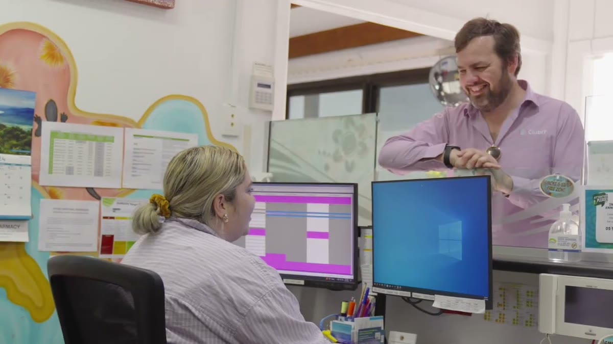 A ClubIT engineer working alongside a staff member at the
               reception workstation of Bullinah Aboriginal Health Service